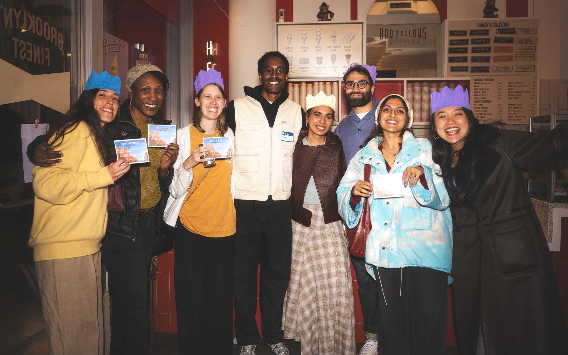 Members of the In Between community at a Brooklyn ice cream shop, wearing paper crowns.